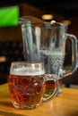 Mug with beer and a jug on a wooden table Royalty Free Stock Photo