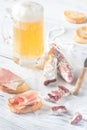 Mug of beer with sandwiches and smoked sausage Royalty Free Stock Photo