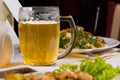 Mug of Beer on Table Amongst Plates of Food Royalty Free Stock Photo