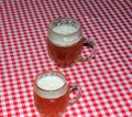 A mug of beer on a table covered with a red checkered tablecloth Royalty Free Stock Photo