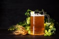 Mug of beer with wheat and hop cones on dark wooden background. October fest background Royalty Free Stock Photo