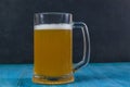Mug of beer on wooden table on dark background Royalty Free Stock Photo