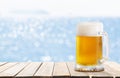 mug of beer on wooden table on sea background Royalty Free Stock Photo