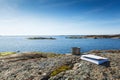 A mug with a book on a stone seashore.