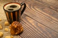Mug with cA mug of coffee, pieces of brown cane sugar, and a cake on the wooden table. Close up.offee, cake, sugar Royalty Free Stock Photo