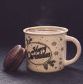 Mug of cappuccino with cinnamon and chocolate chip cookies on dark blue background.The inscription on the mug Merry Christmas. Royalty Free Stock Photo