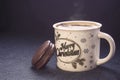 Mug of cappuccino with cinnamon and chocolate chip cookies on dark blue background.The inscription on the mug Merry Christmas. Royalty Free Stock Photo