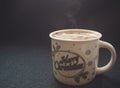 Mug of cappuccino with cinnamon on a dark blue background.Cinnamon powder was sprinkled with 2020 figures on coffee foam.