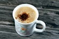 A mug of cappuccino topped with creamy froth and coffee, an espresso-based coffee drink that is traditionally prepared with