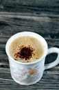 A mug of cappuccino topped with creamy froth and coffee, an espresso-based coffee drink that is traditionally prepared with