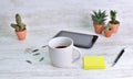 Mug of coffee on a desk with pen  and note paper clip and cactus potted Royalty Free Stock Photo