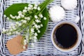 Mug of coffee, marshmallows and flowers lie on a blue table