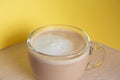 Mug of coffee with milk and froth on a yellow background. Energy and cheerfulness in the morning Royalty Free Stock Photo