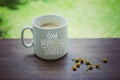 Mug of coffee. Morning white coffee with greeting text on it - Good Morning Sunday, and yellow little flowers arrangement.