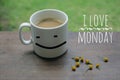 Mug of coffee with smiling happy face. Morning white coffee. I love Monday. Cup of coffee with yellow little flowers arrangement