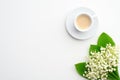 Mug of coffee and spring flowers lily of the valley on white background. Top view with copy space. Good morning, romantic