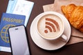 Mug of coffee with WiFi sign on the foam. Free access point to the Internet WiFi. I like coffee break with croissant Royalty Free Stock Photo