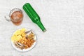 Mug of cold beer, bottle and snacks on the light wooden background. Chips, croutons, salted fish and peanuts. Royalty Free Stock Photo