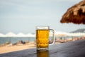 Mug of cold beer with foam on the table. Royalty Free Stock Photo