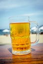 Mug of cold beer with foam on the table. Royalty Free Stock Photo