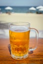 Mug of cold beer with foam on the table. Royalty Free Stock Photo