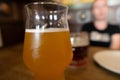 Mug of cold beer with misted glass.  Girl in blur on background Royalty Free Stock Photo