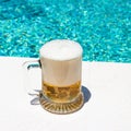 Mug with cold light beer on the outdoor pool Royalty Free Stock Photo