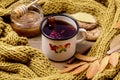 Mug or Cup of Hot Berry Tea With Yellow Warm Knitted Scarf Autumn Maple Leaves Wooden Background Autumn Cold season Royalty Free Stock Photo