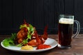 Mug of dark beer with delicious hot crusty grilled chicken wings Royalty Free Stock Photo