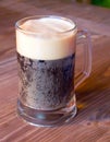 Mug dark beer on a wooden table Royalty Free Stock Photo