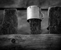 A mug on the fence. Rustic still life. Black and white Royalty Free Stock Photo