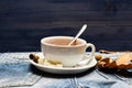 Mug filled with black brewed tea, spoon and autumn fallen leaves on denim background. Autumn drink concept. Tea served Royalty Free Stock Photo