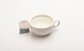 Mug filled with boiling water and teabag on white background. Process of tea brewing in ceramic mug. Tea time concept