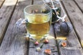 Mug of flavored green tea with rose buds and petals Royalty Free Stock Photo