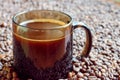 A mug of freshly brewed coffee stands on coffee beans Royalty Free Stock Photo