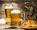 Mug, glass of foamy beer on wooden table Royalty Free Stock Photo