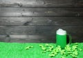 Mug of green beer on green grass with clover leaves on dark wooden planks background. Saint Patricks Day banner, poster, flyer, Royalty Free Stock Photo