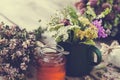 Mug of healing herbs, old tea kettle, honey jar and medicinal plants. Royalty Free Stock Photo