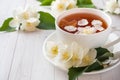 Mug of herbal tea with petals of Jasmine flowers on a light back Royalty Free Stock Photo