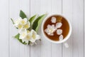 Mug of herbal tea with petals of Jasmine flowers on a light background Royalty Free Stock Photo