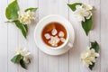 Mug of herbal tea with petals of Jasmine flowers on a light back Royalty Free Stock Photo