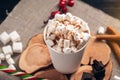 Mug of hot chocolate with marshmallow on top on wooden background. Cozy warm winter rustic composition