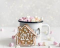 Mug of hot chocolate with marshmallows and a cookie with number 2023