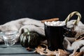 Mug of hot coffee, chocolate with lots of marshmallows and candy, cinnamon, small green pumpkin, candle , and dry autumn leaves , Royalty Free Stock Photo