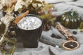 Mug of hot coffee, chocolate with lots of marshmallows , cinnamon, small green pumpkin, candle , dry autumn leaves,  knitted Royalty Free Stock Photo