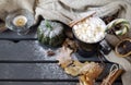 Mug of hot coffee, chocolate with  marshmallows and candy, cinnamon, small green pumpkin, candle , and dry autumn leaves next to a Royalty Free Stock Photo