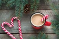 Mug hot coffee with milk, red candy cane in shape of heart on the wooden background. New Year. Holiday card. Rustic style. Top vie Royalty Free Stock Photo