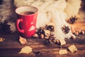 Mug of hot coffee in a woman's hand in a sweater in the autumn setting on a wooden table with a knitted scarf, sweater. Comfort, Royalty Free Stock Photo