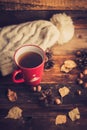 Mug of hot coffee in a woman's hand in a sweater in the autumn setting on a wooden table with a knitted scarf, sweater. Comfort, Royalty Free Stock Photo