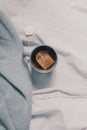 Mug with a hot drink on the bed. Cozy autumn home background
